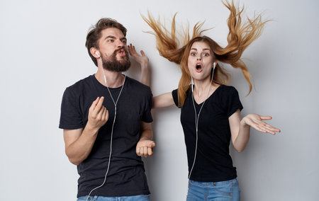 young couple in headphones technology music fun studio isolated backgroundの写真素材