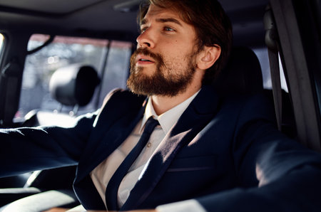 successful young man driving a car in a suit trip lifestyleの写真素材
