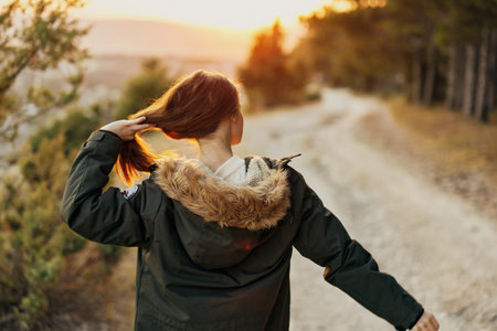 Woman holding hair on nature road hiking fresh airの写真素材