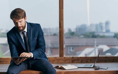 business man in the office with a tablet in his hands near the window Professionalの写真素材
