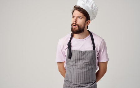 a professional chef in a headdress and an apron gestures with his handsの写真素材