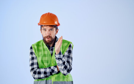 an architect in a helmet and a reflective vest gestures with his hands Copy Space