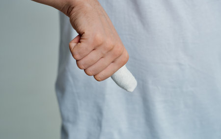 man in white t-shirt broken finger bandaged medicine