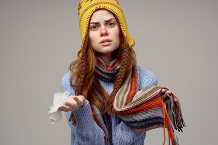 woman with runny nose napkin in hand health problems headacheの写真素材
