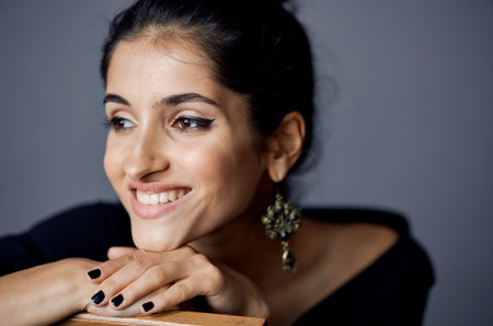 lady in black dress gesturing with hands on gray background cropped viewの写真素材