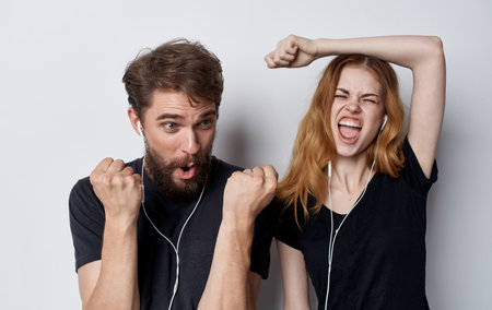 young couple in headphones technology music fun studio isolated backgroundの写真素材
