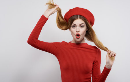 Pretty woman in a simple dress and in a hat holds her hair emotions smileの写真素材