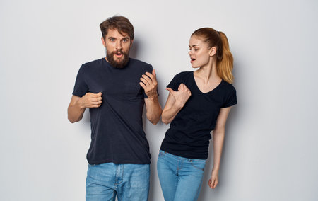cheerful man and woman in black t-shirts studio casual clothes isolated backgroundの写真素材