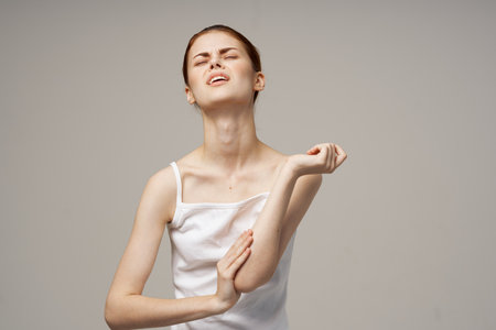 woman in white t-shirt problems with trunks pain osteoporosisの写真素材