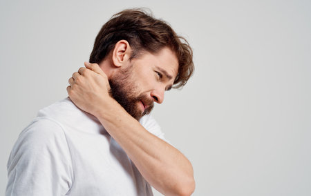 young man touching neck with hands spine pain side view model portraitの写真素材