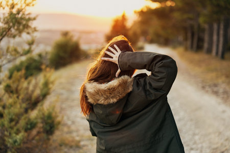 woman outdoors in jacket fresh air sun back viewの写真素材