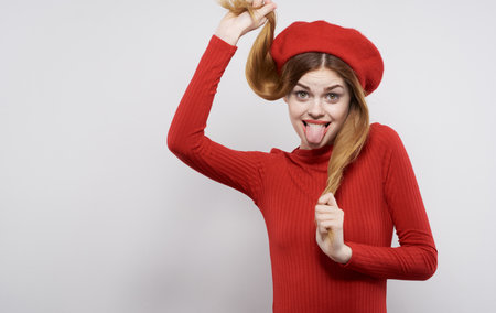 Pretty woman in a simple dress and in a hat holds her hair emotions smileの写真素材