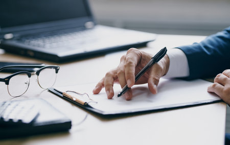 documents office laptop stationery business finance mens hands and glassesの写真素材