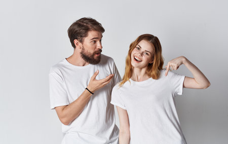 couple in love man and woman in the same t-shirt friends light backgroundの写真素材