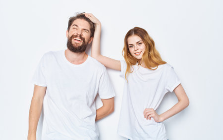 Enamored woman and man t-shirts family friends having fun gesturing with their handsの写真素材