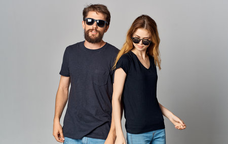 young couple in black t-shirts sunglasses studio romance communication elegant styleの写真素材