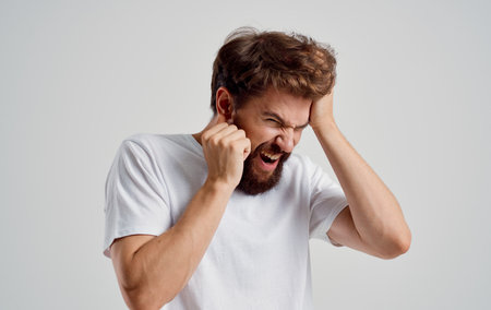bearded man holding his head discontent migraine health problemsの写真素材