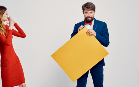 Energetic woman and men with yellow sheet of paper Poster mockup advertisementの写真素材