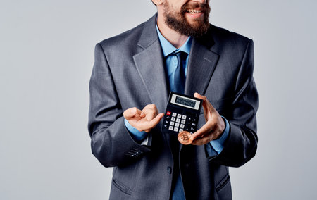 A man in a classic suit controls the hands and coins of the Bitcoin cryptocurrencyの写真素材