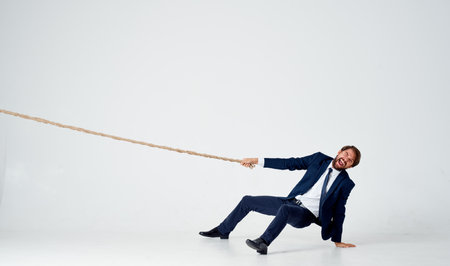 man with rope in hand on light background business financeの写真素材