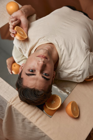 Handsome man lies on the mirror studio oranges lifestyleの写真素材