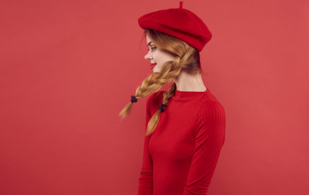 pretty woman in red dress caps pigtails red backgroundの写真素材