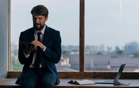 A man in a suit with a tablet in the hands of an office official, a professional businessmenの写真素材
