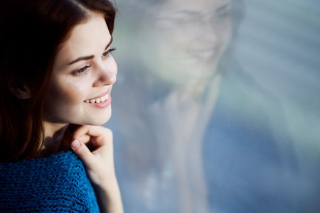 smiling woman hiding with a blanket near the window rest morning sun