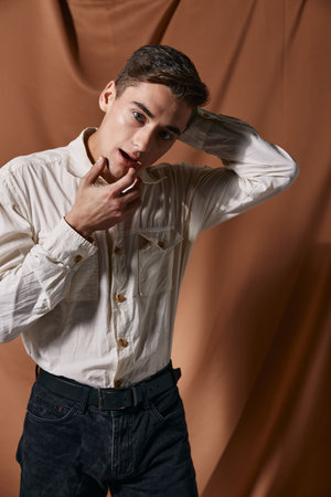 A man in a white shirt holds his hands near his head modern style self-confidence model