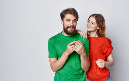 young couple in multicolored t-shirts emotions studio friendshipの写真素材