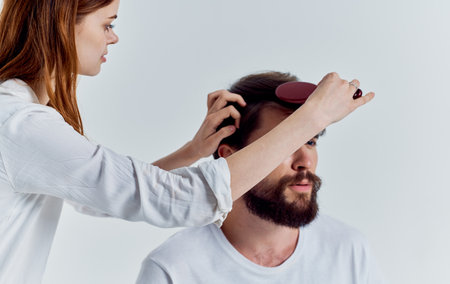 woman with comb doing hair to man professional hairdressing beauty salonの写真素材
