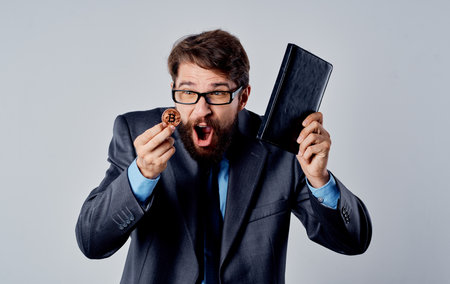 Businessman in suit with cryptocurrency in hand Bitcoin coin documentsの写真素材