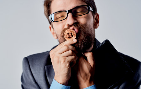 Man with a coin in his hands cryptocurrency Bitcoin glasses business finance modelの写真素材