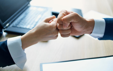 employees shaking hands at work in the office agreement document laptopの写真素材