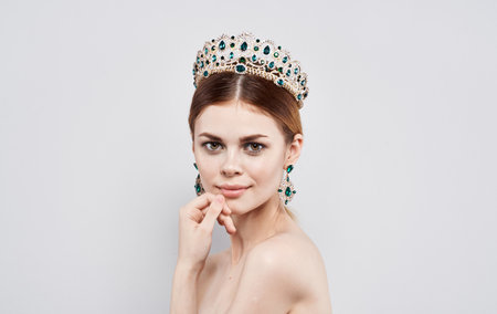 Beautiful woman with diadem on her head Princess queen model with earrings portraitの写真素材