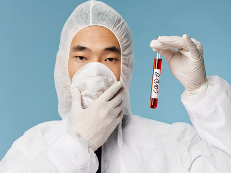 male laboratory technician protective clothing covid-19 blood test close-upの写真素材