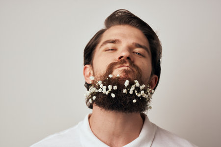 Handsome man flowers in beard ornaments elegant style close-upの写真素材