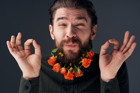 Bearded man with flowers decoration romance attractive look close-upの写真素材