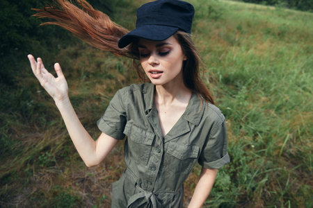 Woman in the forest eyes closed black cap green suit treesの写真素材