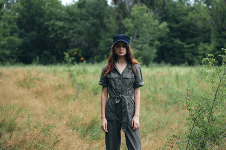 woman in nature in a gray overalls and a cap on her headの写真素材