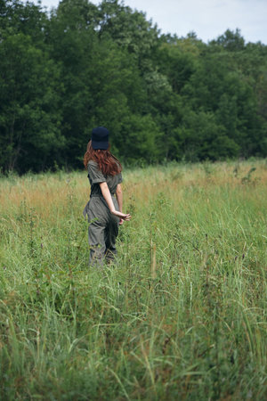 Woman on nature Walking through the field fresh air travel back view