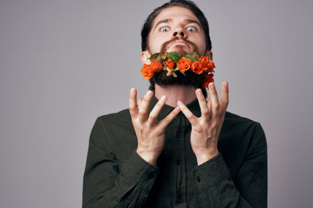 handsome man flowers in a beard Decoration close-up gray backgroundの写真素材
