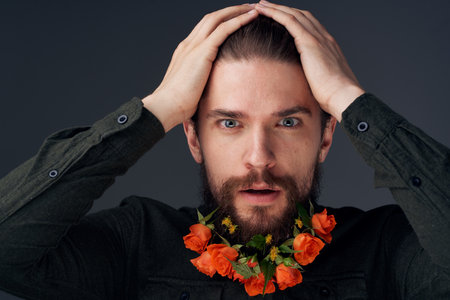 man flowers decoration in beard emotions black backgroundの写真素材