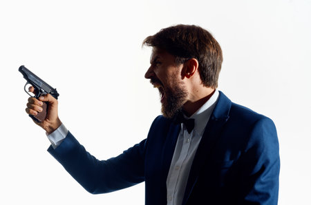 business man in a suit with a gun in his hands detective caution crimeの写真素材