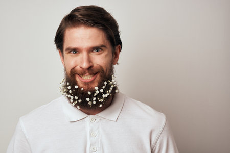 Elegant man in a white shirt flowers in a beard decoration emotions studio light background