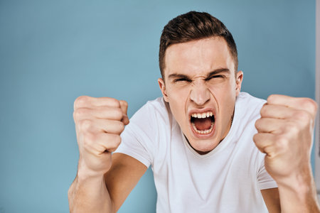 Man gestures with his hands emotions white t-shirt expression blue backgroundの写真素材