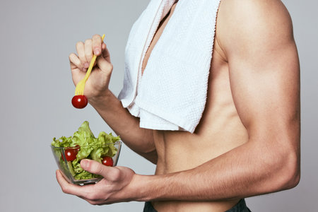 a man with a towel on his shoulders a plate of salad healthy food dietの写真素材