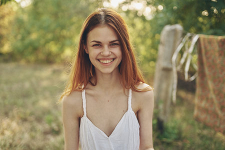 a woman near the rugs hung on a rope outdoors in the yardの写真素材