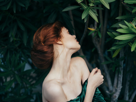Pretty woman glamor green leaves luxury posing outdoorsの写真素材