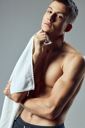 sporty man pumped up body with towel in hands close-up cropped viewの写真素材
